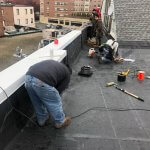 Crew working on a flat roof in downtown Malden